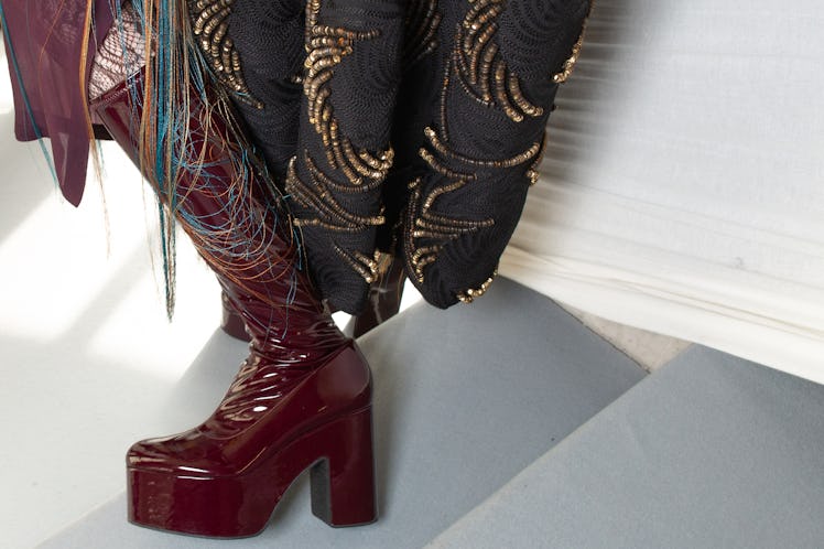 A female model wearing a burgundy heel boot