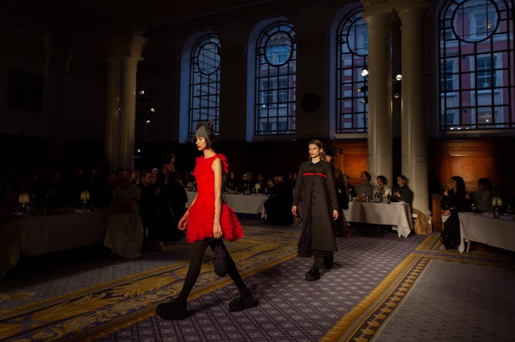 A model wearing a red dress and a model wearing a black coat at Molly Goddard’s London Fashion Week ...