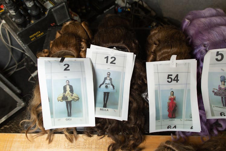 Four small photographs of models attached to wigs backstage at the Moschino Fall 2020 show