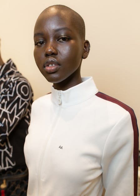 A model in a white zip-up jacket backstage at the Tory Burch Fall 2020 show