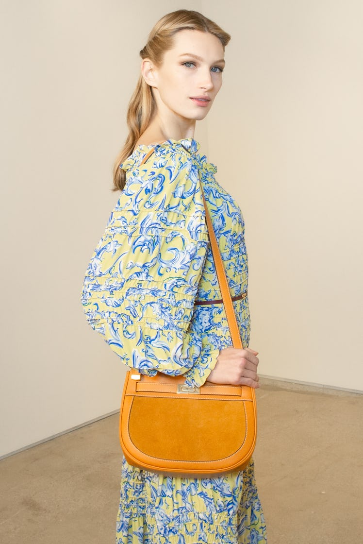 A blonde woman posing in a yellow and blue floral dress at the Tory Burch FW20 during New York Fashi...