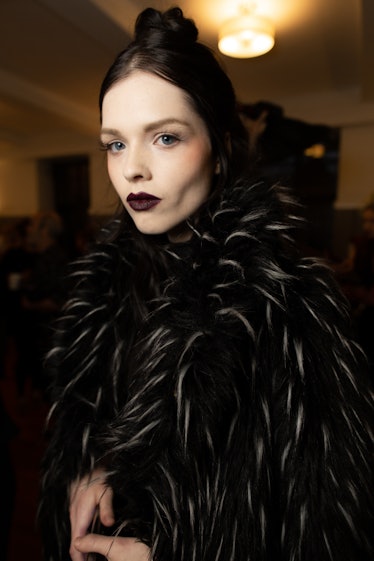 A female model posing while wearing a black fur jacket