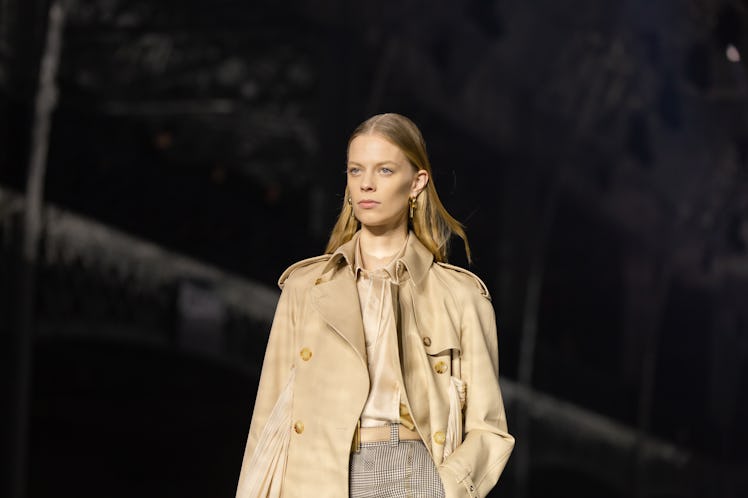 A model wearing a beige top, grey trousers and a beige coat at the Burberry Fall 2020 show