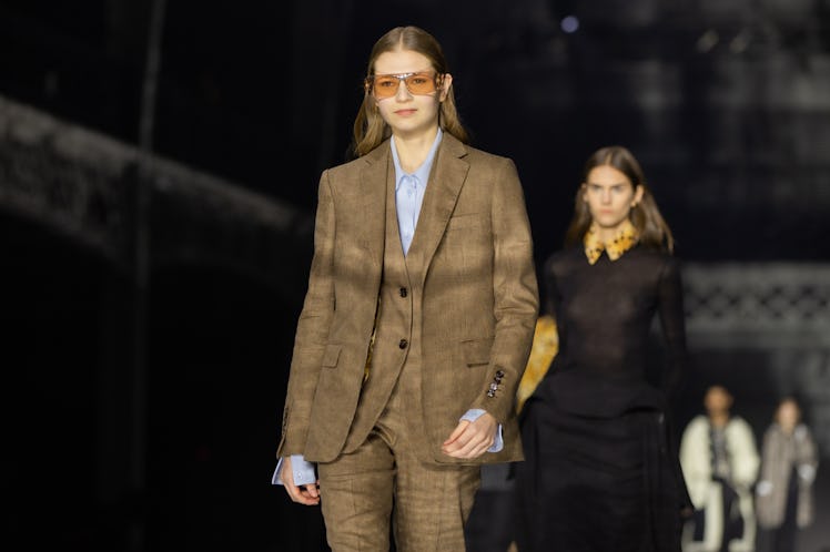 A model wearing a brown suit, a blue shirt and orange sunglasses at the Burberry Fall 2020 show