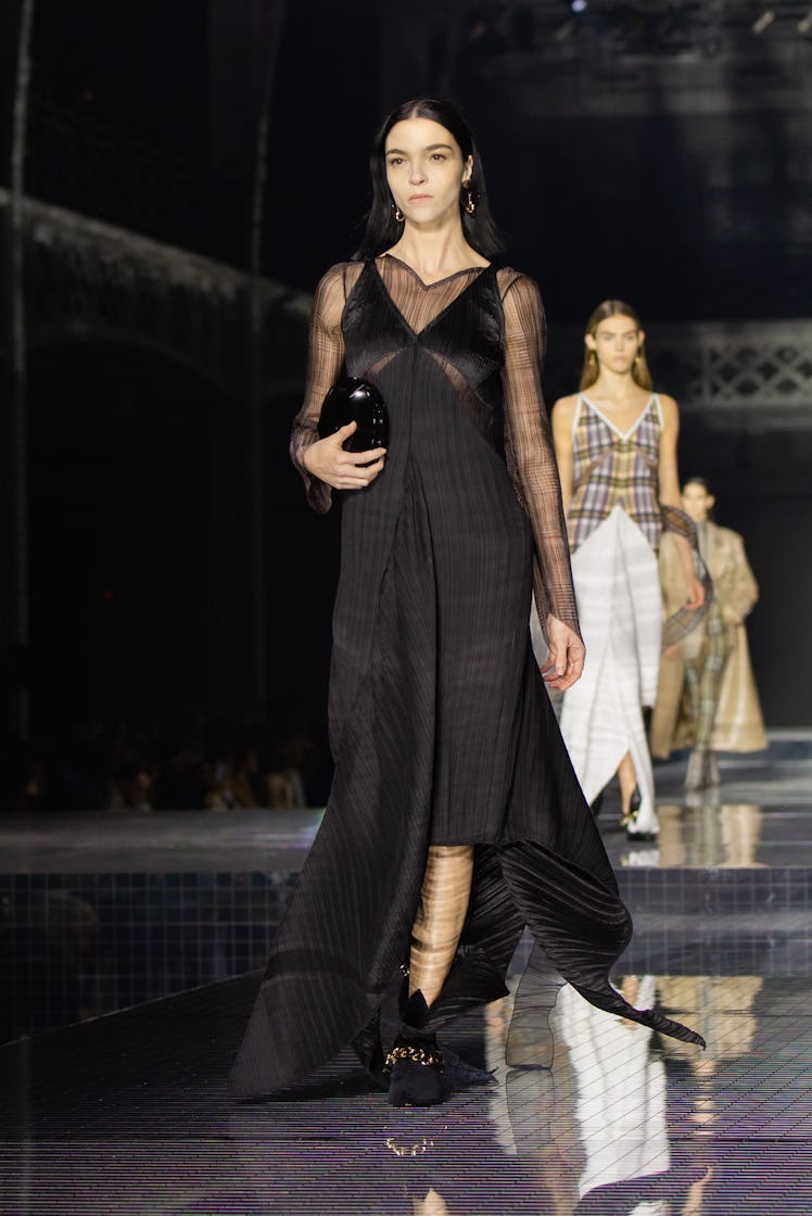 A model wearing a black dress with tulle details and a black bag at the Burberry Fall 2020 show