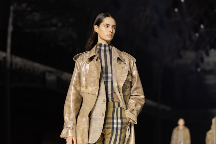 A model wearing a black-brown top and trousers, beige blazer and coat at the Burberry Fall 2020 show