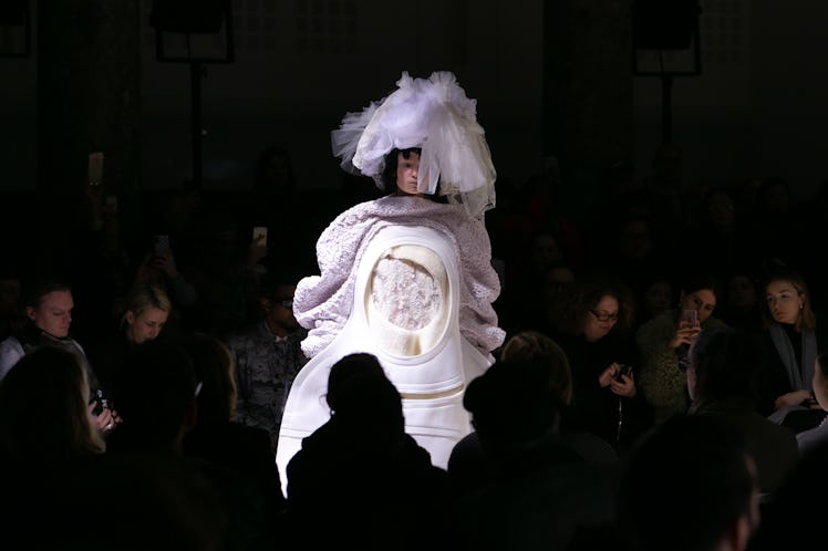 A model on Comme Des Garcons' runway in Paris wearing a large lilac dress with a white opening and a...