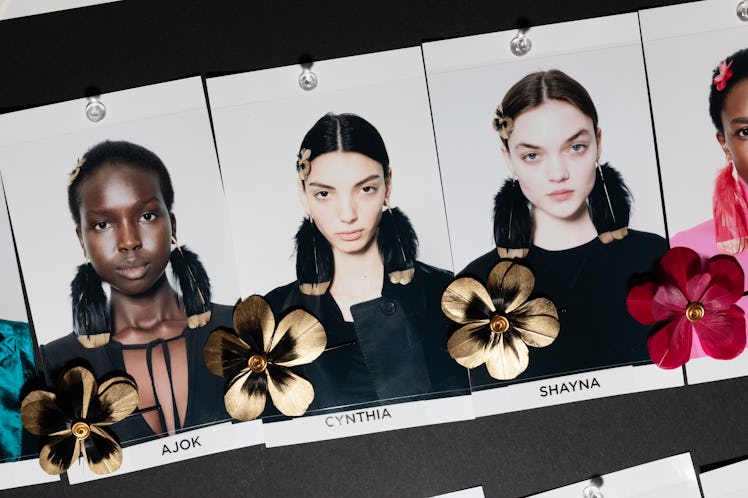 Close up pictures of runway models that are wearing flower shaped badges and earrings