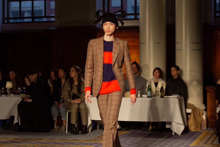 A model in a red-black sweater and a brown checked suit at Molly Goddard’s London Fashion Week Show