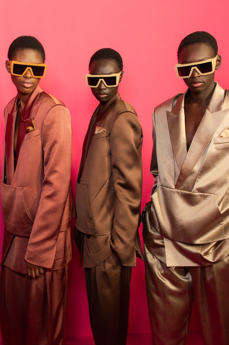 A model in a pink, brown and beige satin suit backstage at Balmain Fall 2020