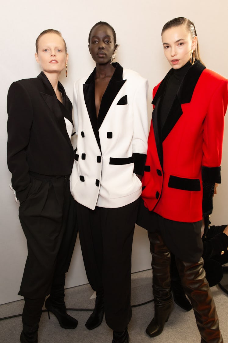 A model in a black, white and a red suit backstage at Balmain Fall 2020