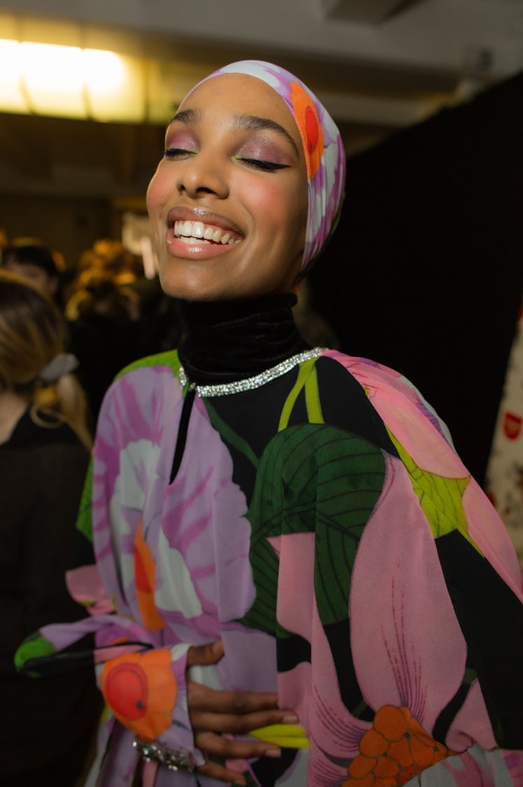 A model in a pink-green floral dress and headscarf at Richard Quinn‘s fall collection