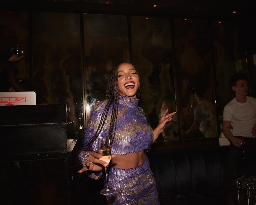 Tinashe wearing a purple crop top and matching skirt while leaving a party