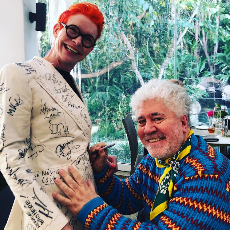 Sandy Powell taking a signature from Pedro Almódovar on her white suit costume