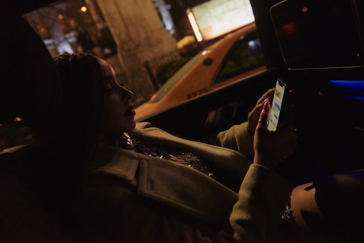 Tinashe using her mobile phone while sitting in a car