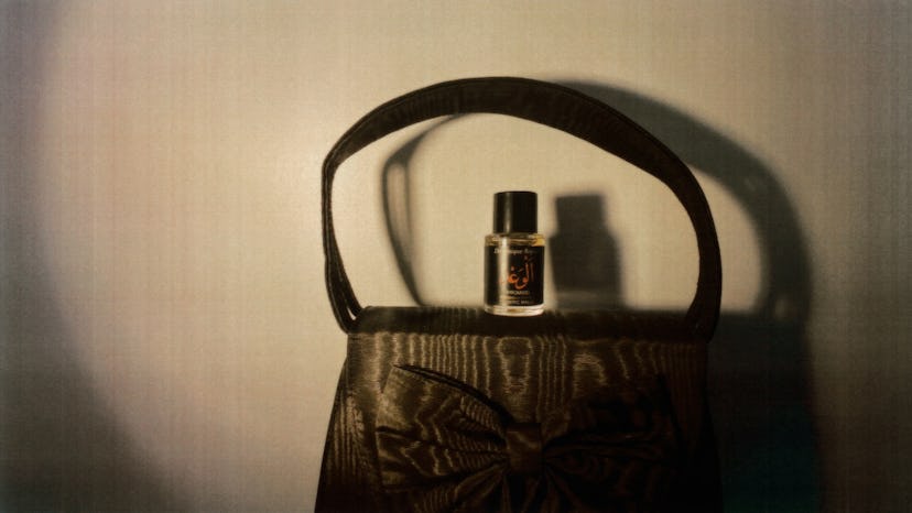 A bottle of perfume placed on a small handbag as a Valentine's Day gift