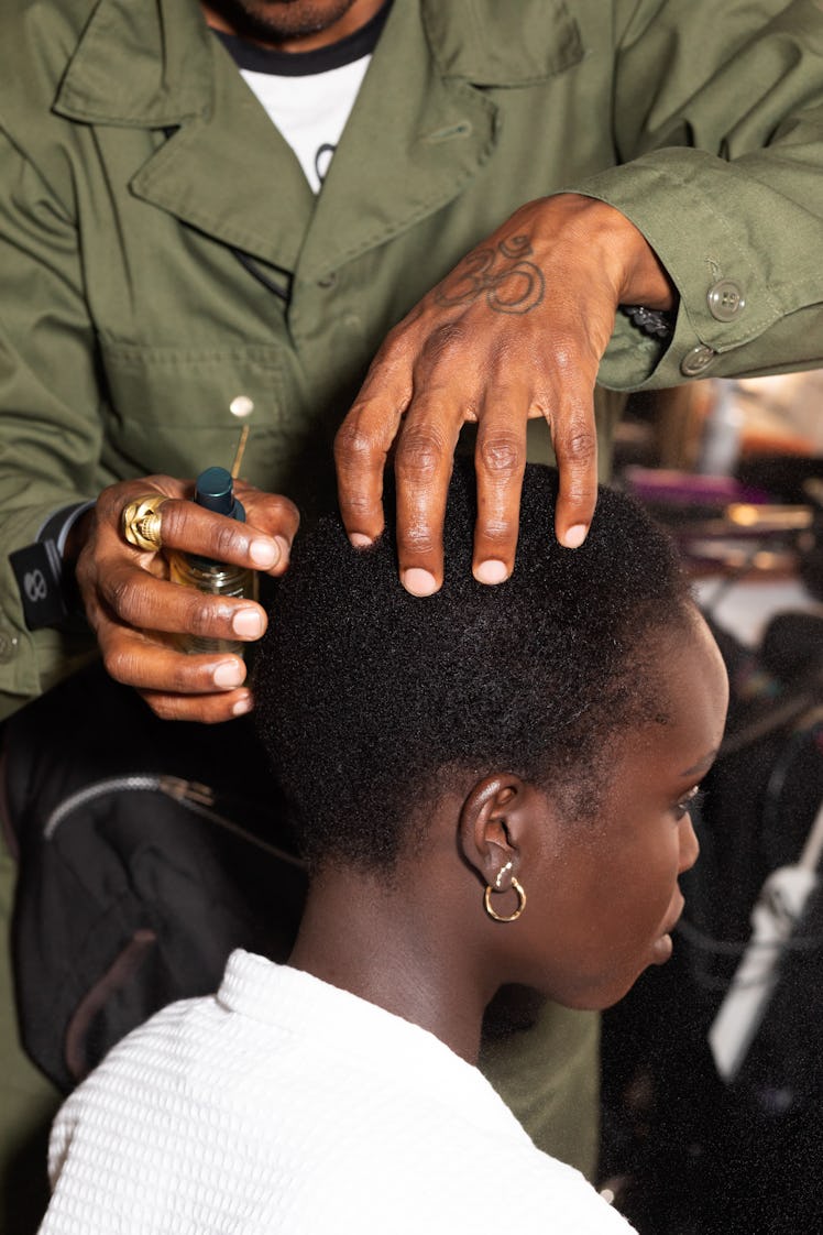 Hairdresser massaging model's scalp before going to a runway