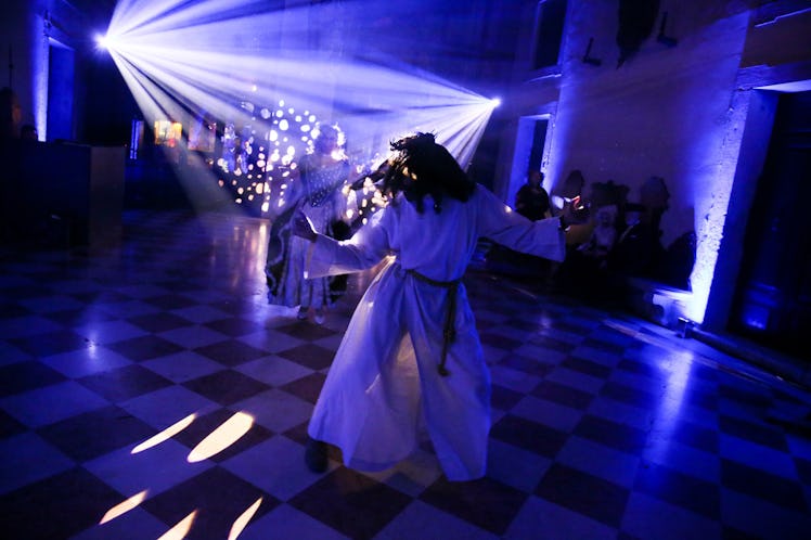 A man dancing on the floor in a white dress at the Save Venice party