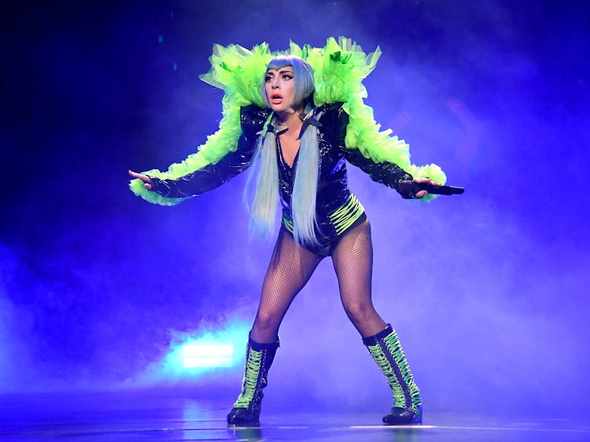 Lady Gaga in concert with green feathers.