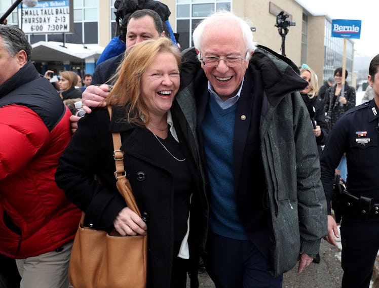 Bernie and Jane Sanders smiling while posing for a photo on the street.