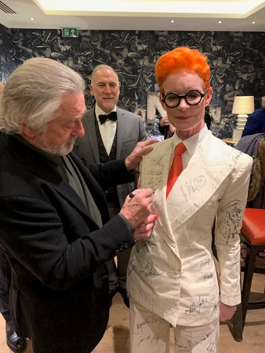 Sandy Powell taking a signature from Robert De Niro on her white suit costume
