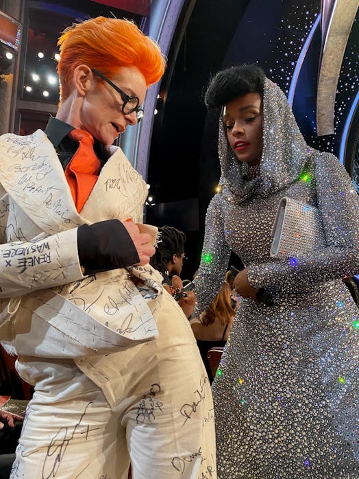 Sandy Powell taking a signature from Janelle Monae on her white suit costume