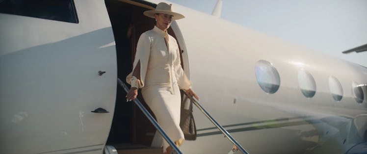 Diana Ross leaving a plane while wearing a white dress and a white hat in a Mahogany scene