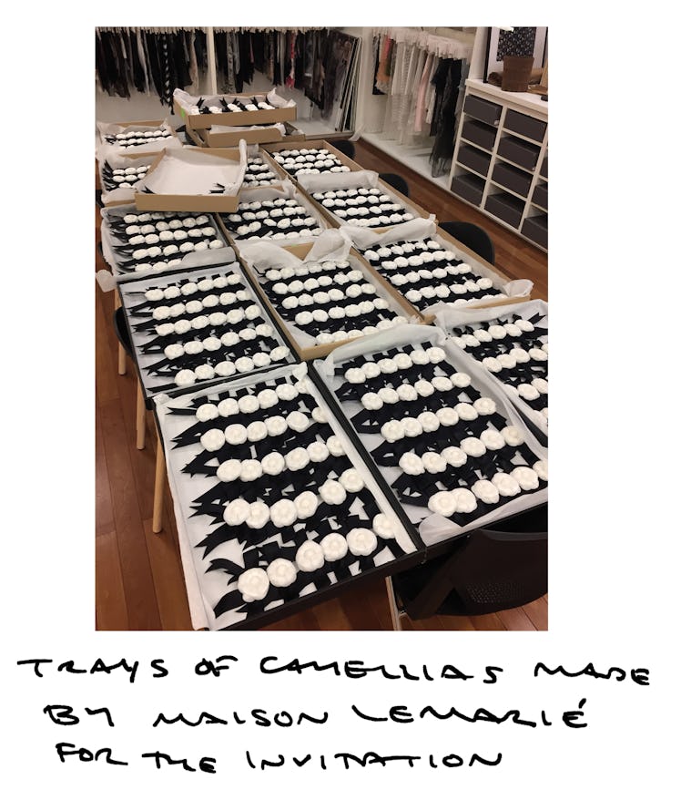 Fifteen trays with white-black camellias on a large table by Chanel