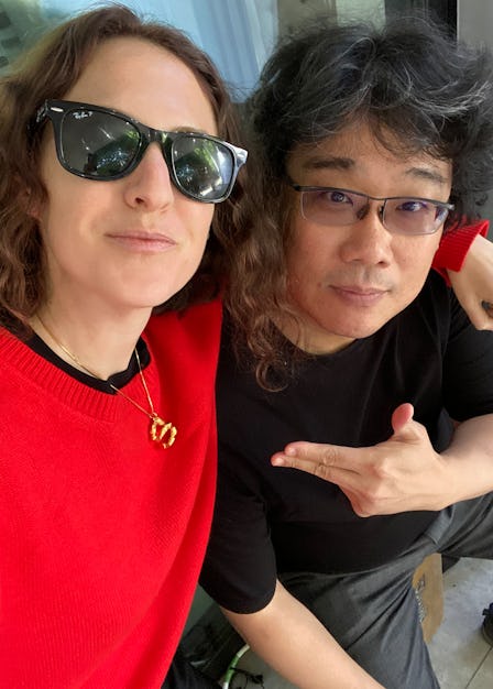 Sara Moonves in a red sweater and Bong Joon Ho in a black shirt taking a selfie