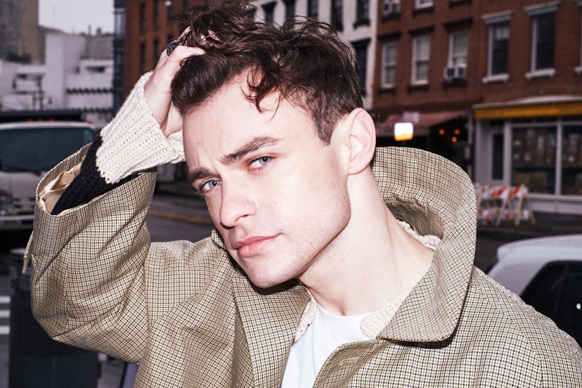 Thomas Doherty tussles his hair.