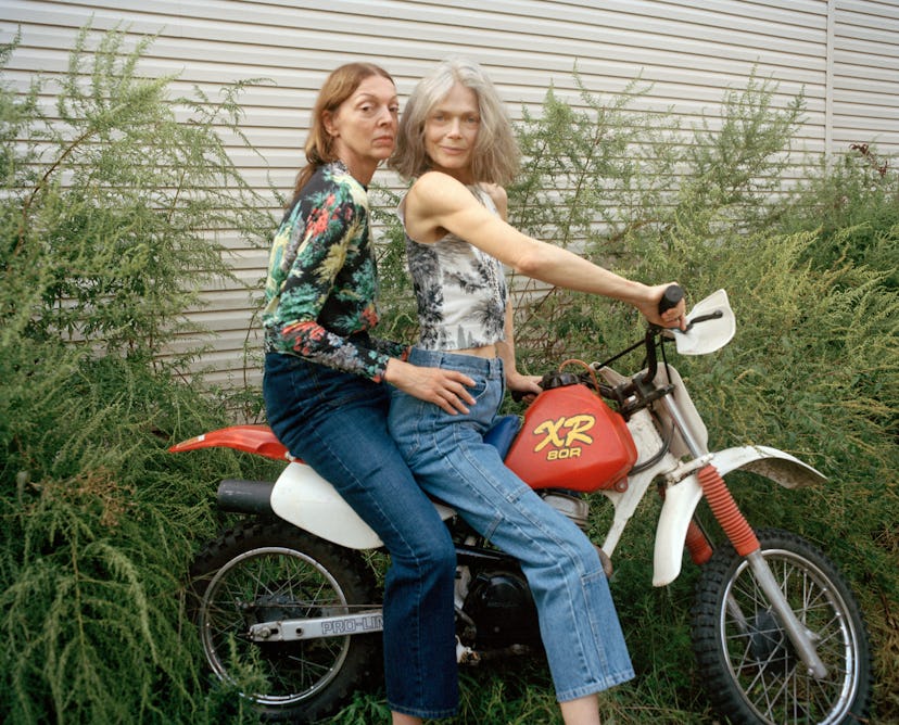 Two older female models posing on a motorcycle