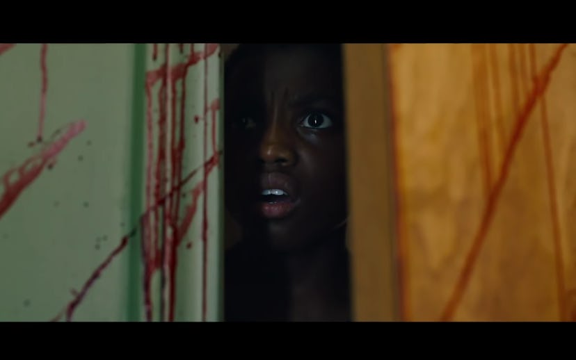 A scene from the Candyman trailer of a child peaking out of a slightly opened door
