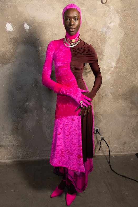 A model wearing a pink-burgundy dress by Marine Serre backstage