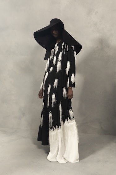 A model in a black-white coat, white skirt and and a black hat at the Givenchy Fall 2020
