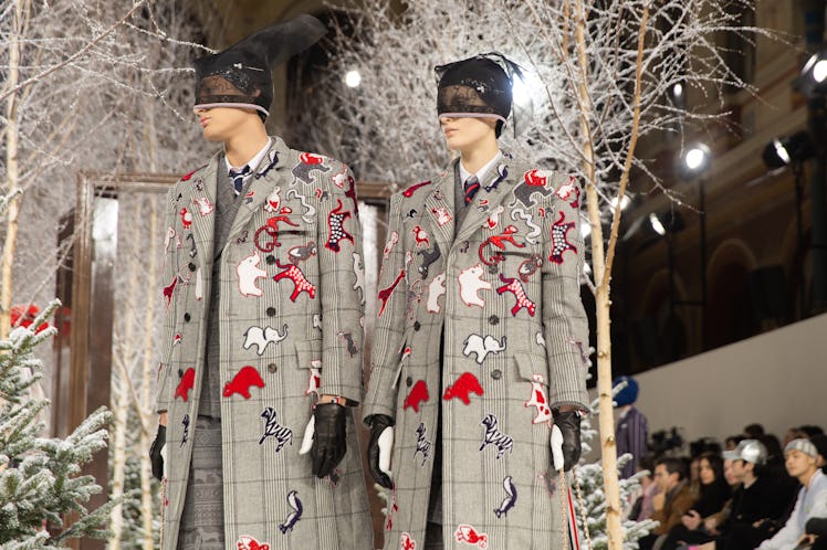 Models on Thom Browne's fall 2020 runway during Paris Fashion Week in beige plaid jackets with anima...