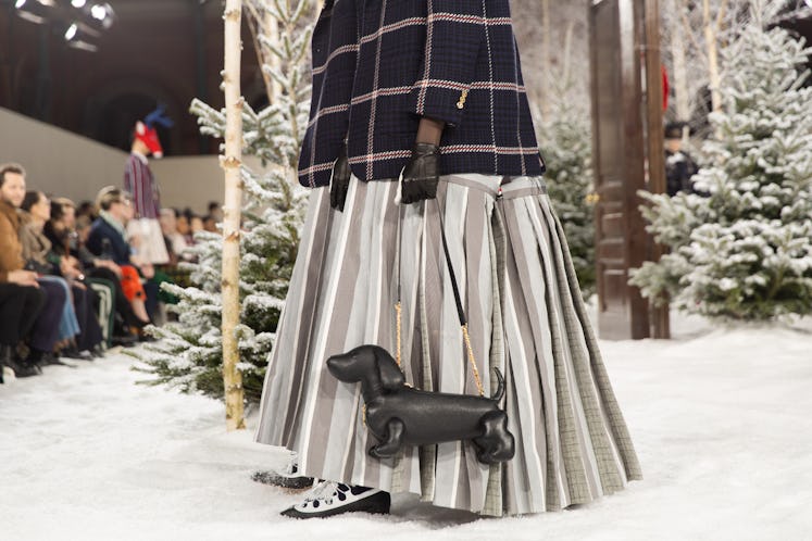 A model on Thom Browne's fall 2020 runway during Paris Fashion Week in a pleated grey silk skirt and...