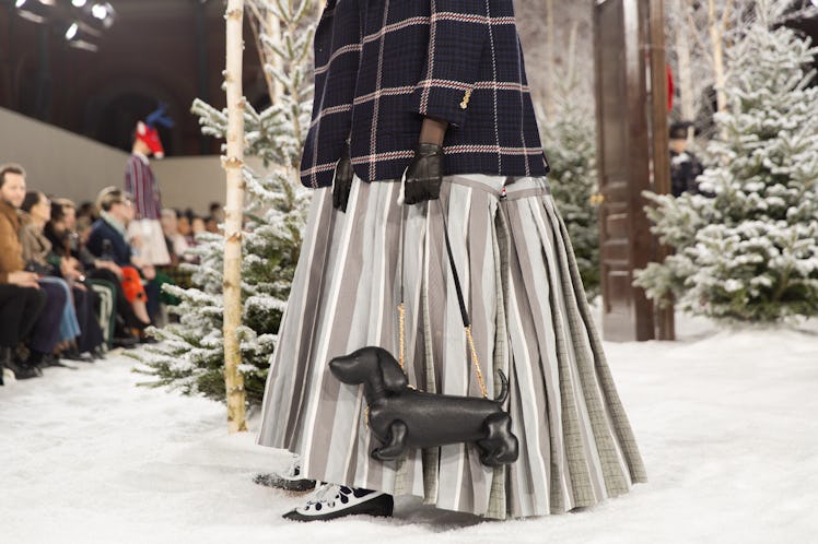 A model on Thom Browne's fall 2020 runway during Paris Fashion Week in a pleated grey silk skirt and...