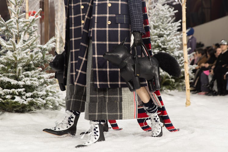 Models on Thom Browne's fall 2020 runway during Paris Fashion Week in plaid jackets and carrying dog...