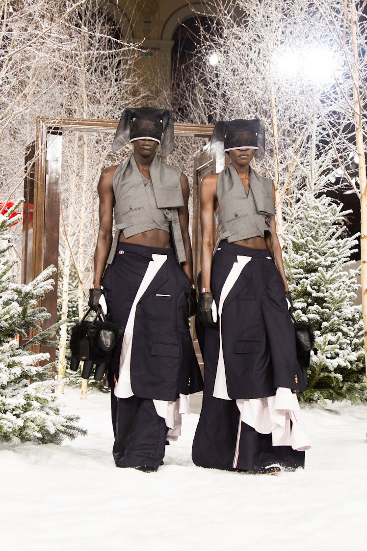 Models on Thom Browne's fall 2020 runway during Paris Fashion Week in cropped grey vests, black pant...