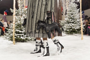 Models on Thom Browne's fall 2020 runway during Paris Fashion Week carrying a horse-shaped black bag...