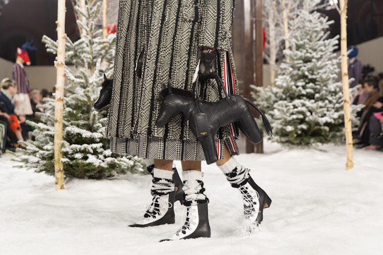 Models on Thom Browne's fall 2020 runway during Paris Fashion Week carrying a horse-shaped black bag...