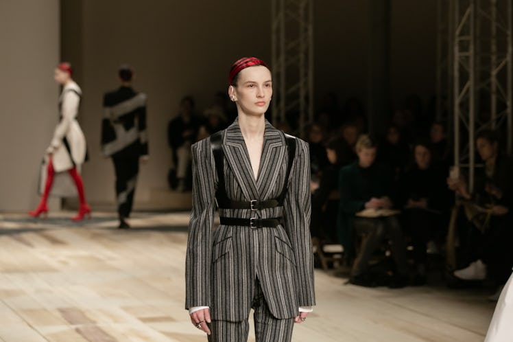 A model in a striped grey suit and black harness at the Alexander McQueen Fall 2020 show