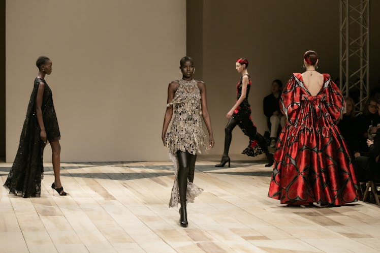 A model in a grey dress, black dress and red gown at the Alexander McQueen Fall 2020 show