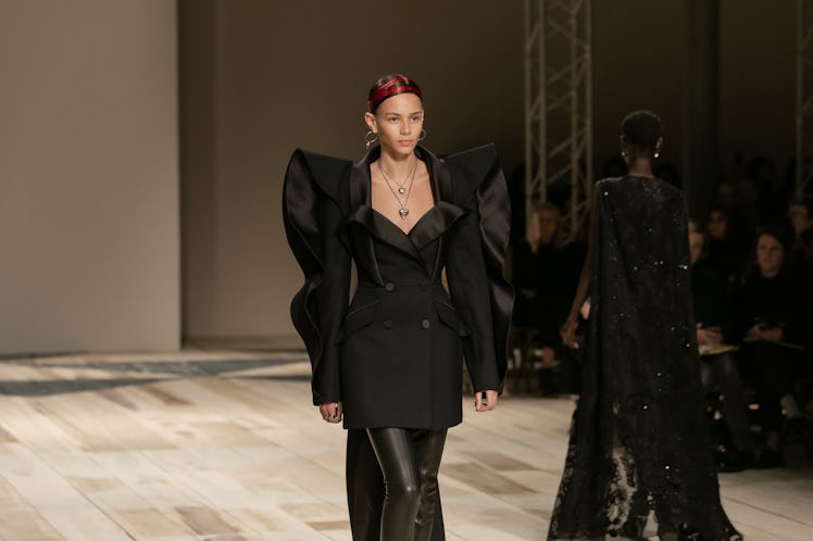 A model in a black coat and black trousers at the Alexander McQueen Fall 2020 show