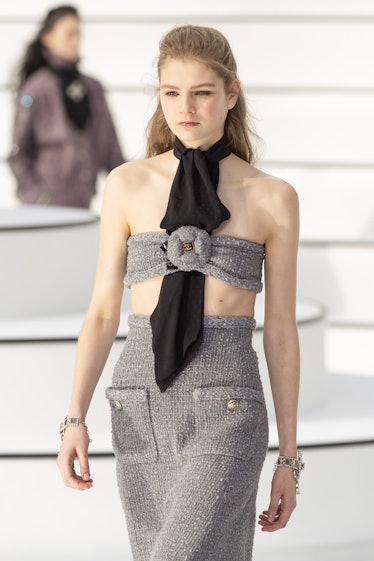 A model walking in a black-grey bandeau top and skirt at the Chanel fall 2020 show