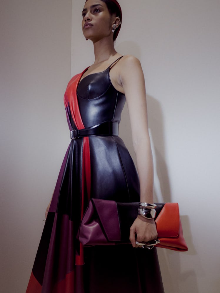 A model in a black-red dress and matching purse at the Alexander McQueen Fall 2020 show