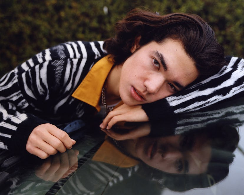 Conan Gray lies on a windshield.