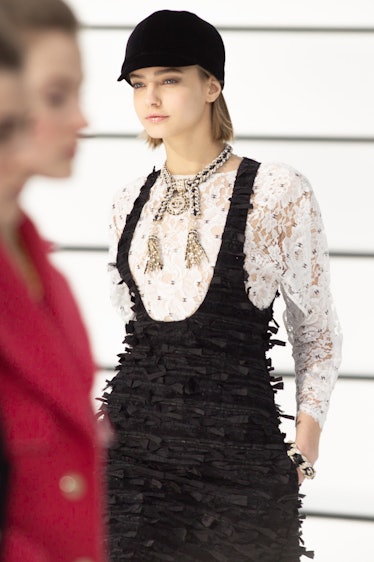 A model in a white lace top and black dress at the Chanel fall 2020 show