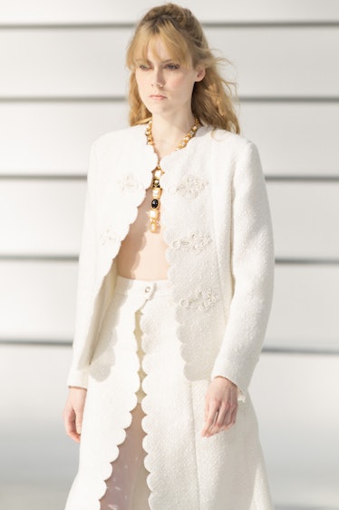 A model in a white jacket and a white skirt at the Chanel fall 2020 show