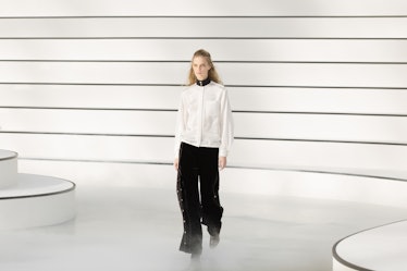 A model walking in a white shirt and black trousers at the Chanel fall 2020 show